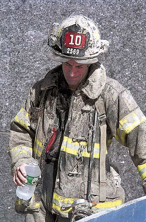 A tearful Firefighter is photographed moments after he escaped from the north tower of the World Trade Center on Sept. 11. The collapse of the tower behind was imminent. He survived, but five other firefighters from Ten House would perish. Photo supplied by Mary Altaffer.  © 2002 Appleton Post-Crescent