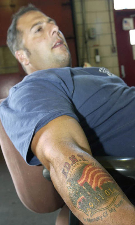 Pete D'Ancona, a firefighter with Ladder 10, displays a tattoo he got shortly after Sept. 11.  Photo by Mike De Sisti 8/10/02 © 2002 Appleton Post-Crescent