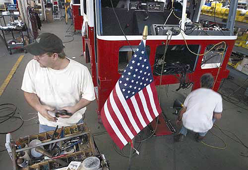 ON THE LINE: Seagrave employees Roger Kohn (left) of Tigerton and Bill Berwig of Clintonville work Oct. 30 on the wiring of a fire truck being built for New York City in the aftermath of the Sept. 11 terrorist attack. By today the company will have delivered 43 of the 54 trucks on emergency order from New York City.  Photo by Dan Powers © 2002 Appleton Post-Crescent