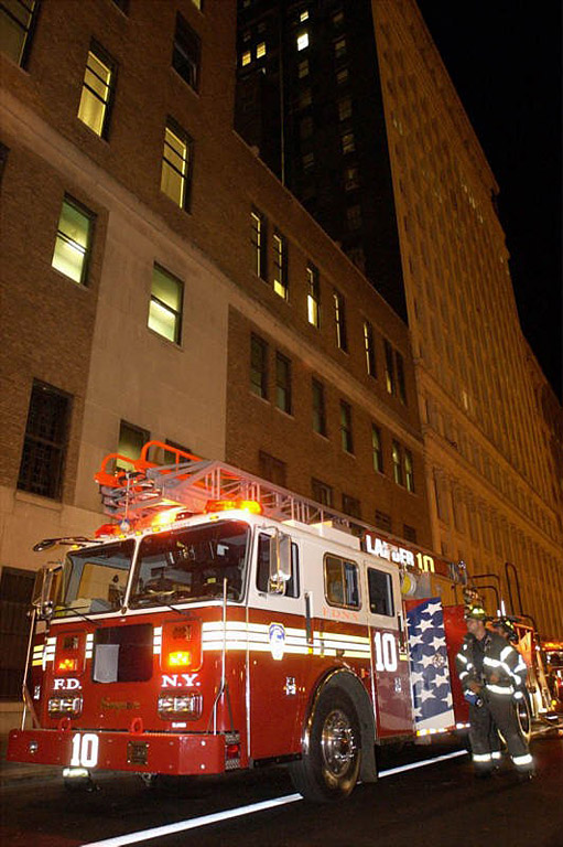 Eddie Thompson of Ladder 10 Company prepares for departure after the company extinguished a garbage fire that burned into the eaves of a large building on Church Street in Manhatten.  Photo by Mike De Sisti 8/7/02 © 2002 Appleton Post-Crescent