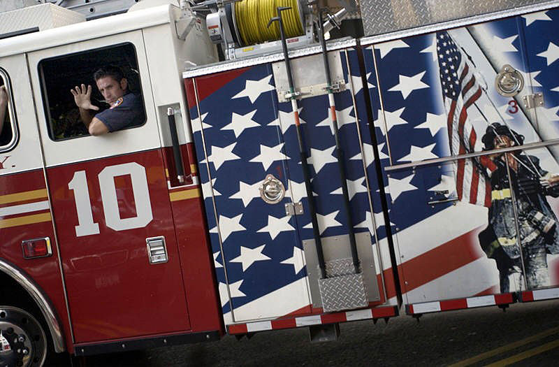 The chauffer of Ladder 10 Company waves to onlookers as Ladder 10 truck passes by.  Photo by Mike De Sisti 8/7/02 © 2002 Appleton Post-Crescent