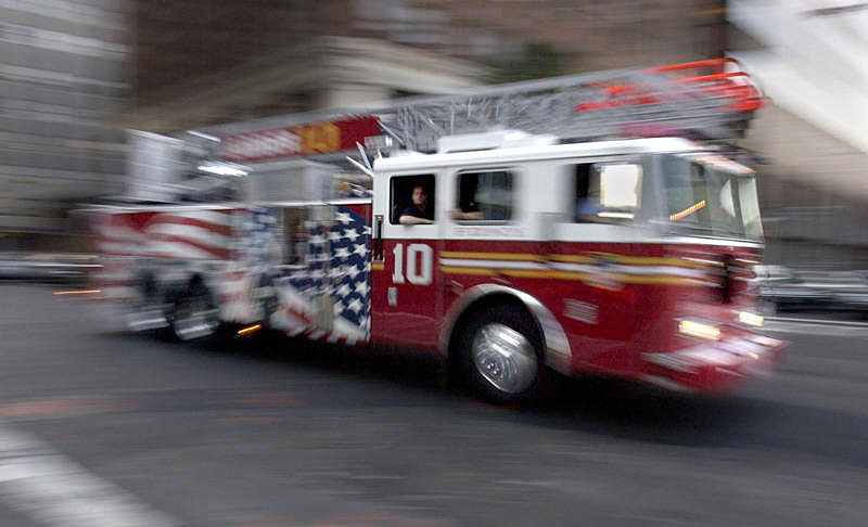 Ladder 10 cruises through Manhattan's financial district. After seeing the specially decorated Seagrave truck at a trade show, Ladder 10 firefighters started a rumor that it was the new Ladder 10 truck, which it indeed became in April.  Photo by Mike De Sisti 8/7/02 © 2002 Appleton Post-Crescent