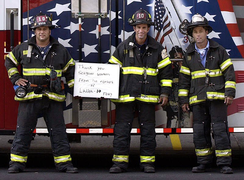 “Thank you Seagrave workers from the members of Ladder 10 — FDNY.”  Ladder Ten Firefighters send a message to the Seagrave workers in Clintonville who built and decorated the ladder company's new fire truck in the aftermath of the Sept. 11 terrorist attacks.  Photo by Mike De Sisti 8/10/02 © 2002 Appleton Post-Crescent