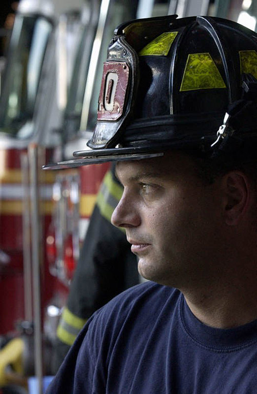 Ladder 10 Company firefighter Kevin Ekberg sits at the company's temporary South Street firehouse in New York.  Photo by Mike De Sisti 8/9/02 © 2002 Appleton Post-Crescent